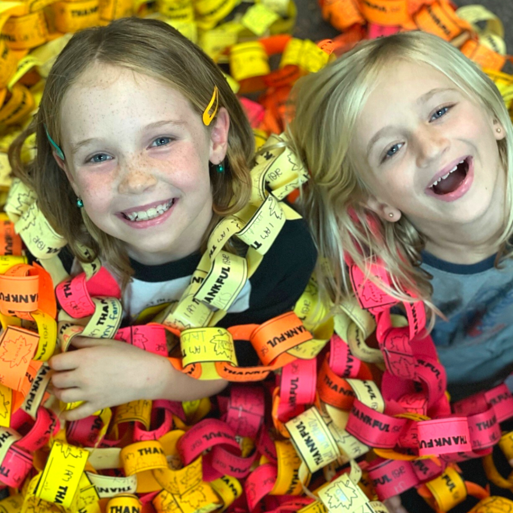 how-to-be-thankful 2 smiling 2nd graders surrounded by a large thankful chain