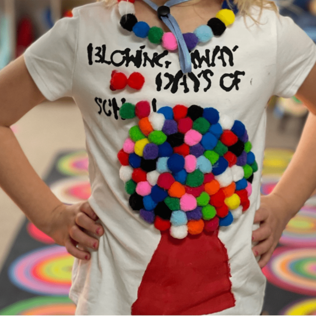 100th day shirt with 100 pom pom balls as gumballs